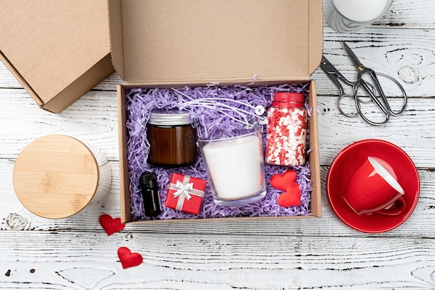 Seasonal gift box for valentine day with candle red cup and heart shape sweets