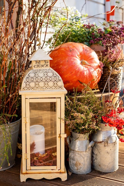 Seasonal home garden autumn decoration with heather flower pot pumpkin and lantern with candle illum