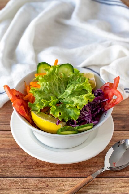 Seasonal salad on wood background Salad made with vegetables close up