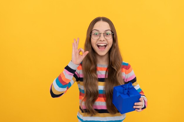 Seasonal sales. amazed teen girl in eyeglasses with box. boxing day. present and gifts buy. shopping child with purchase. kid with box. ok. happy birthday holiday. black friday discount.