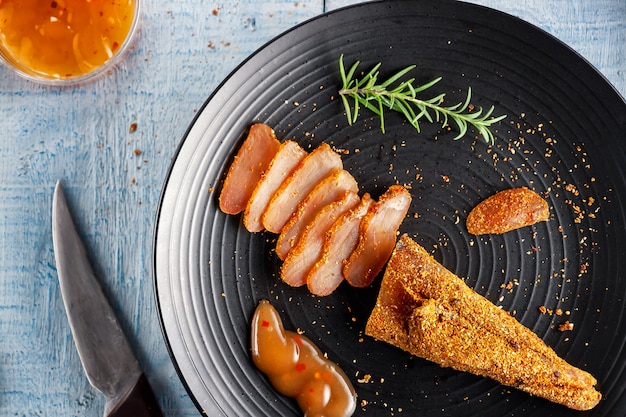 Foto pollo condito con salsa piccante e un rametto di rosmarino