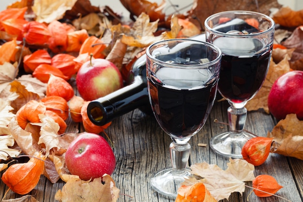 유리에 양념 와인. 테이블에 붉은 잎