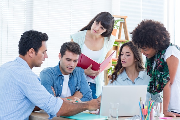 Seated creative business team working on a laptop