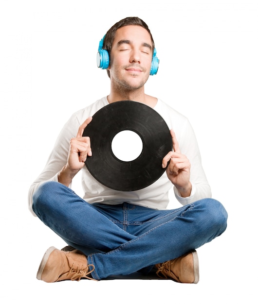 Seated happy young man using a headphones