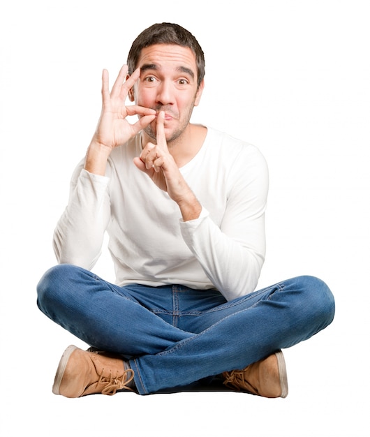 Seated young man keeping a secret