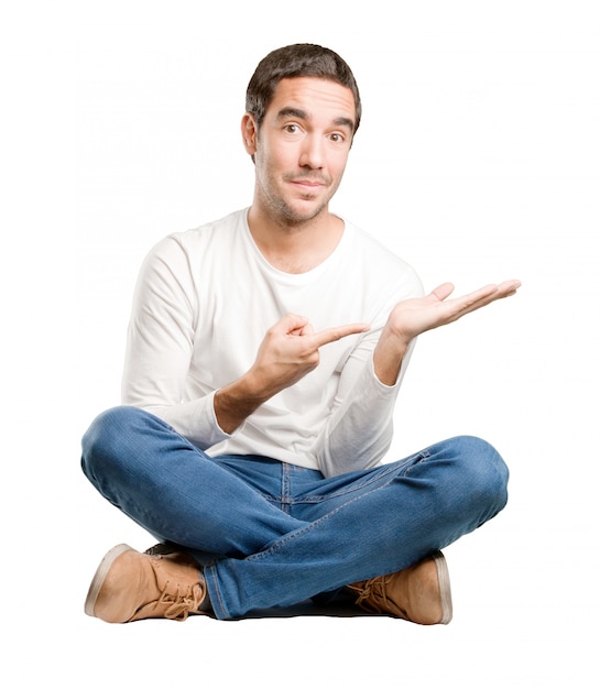 Seated young man showing