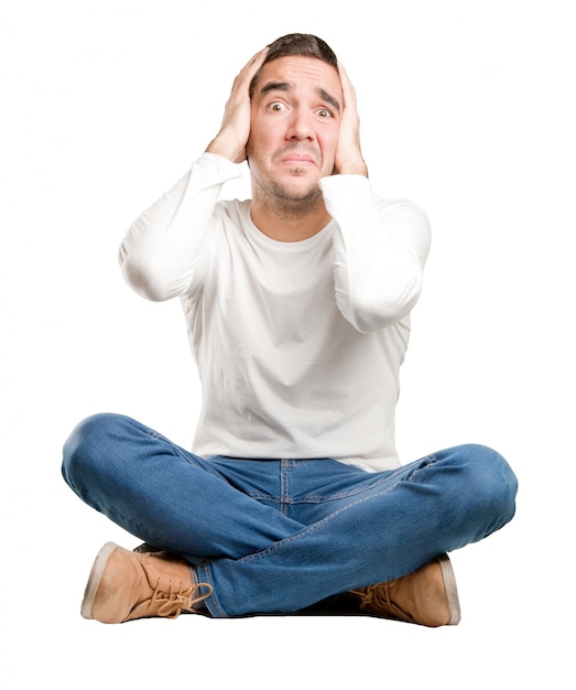 Seated young man with a crazy gesture