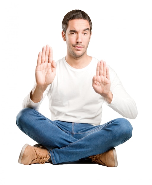 Seated young man with a stop gesture