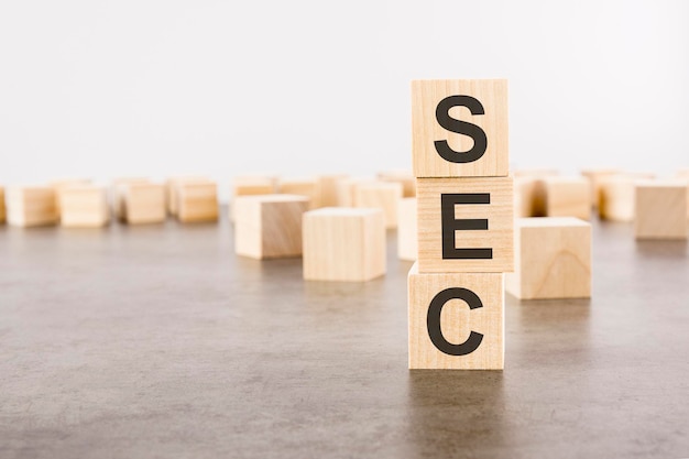 Sec text as a symbol on cube wooden blocks many wooden blocks\
in the background