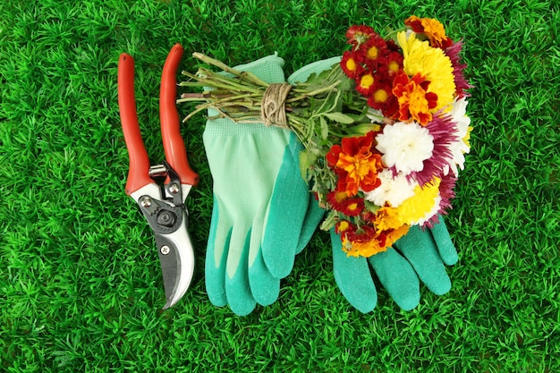 Foto secateurs met bloemen op een achtergrond van groen gras