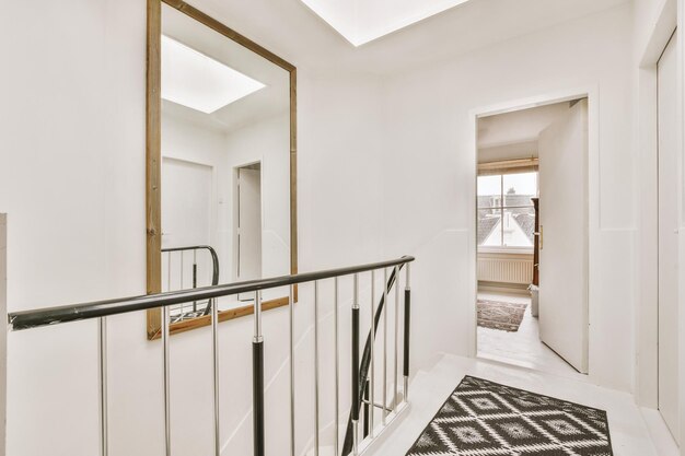 The second floor of a residential building with a large square mirror above the stairs