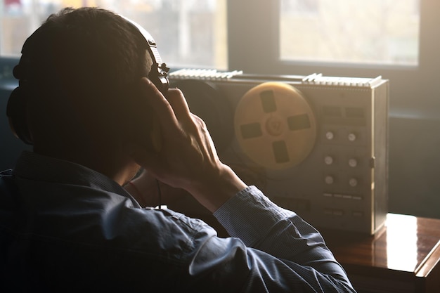Секретный агент слушает катушечный магнитофон Офицер прослушивает телефонные разговоры в наушниках Подслушивание разговоров Сбор разведывательных данных Концепция шпионажа Сообщает информацию начальству