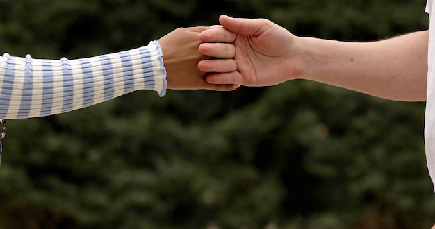 Foto stretta di mano segreta di un uomo caucasico irriconoscibile e di una donna africana.