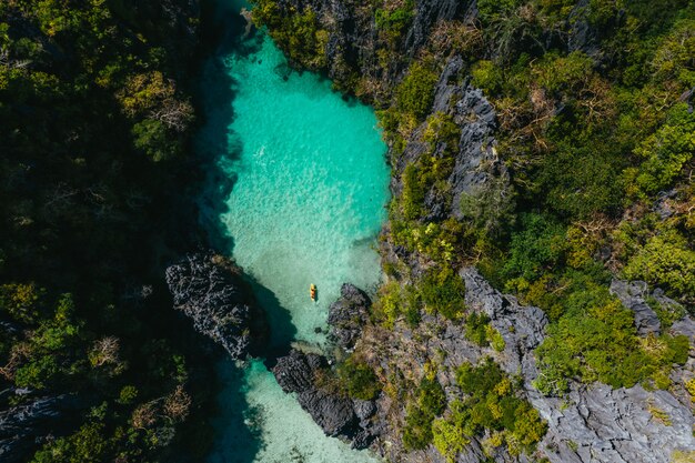 エルニドの秘密のラグーン。透明な水とカヤックで時間を楽しんでいるカップル。旅行と自然についての概念