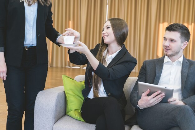 Secretaresse bracht een kopje koffie voor zakelijke bijeenkomst