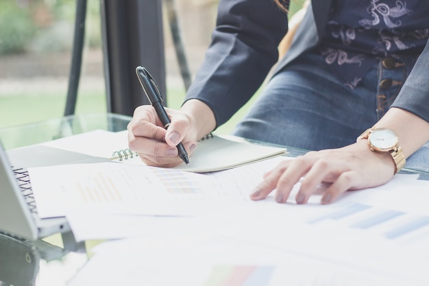 Secretaris notities maken vanaf de telefoon, Business jonge vrouwen werken op telefoons en notebooks.