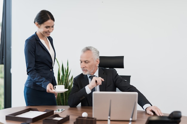 The secretary brought her boss a cup of coffee.