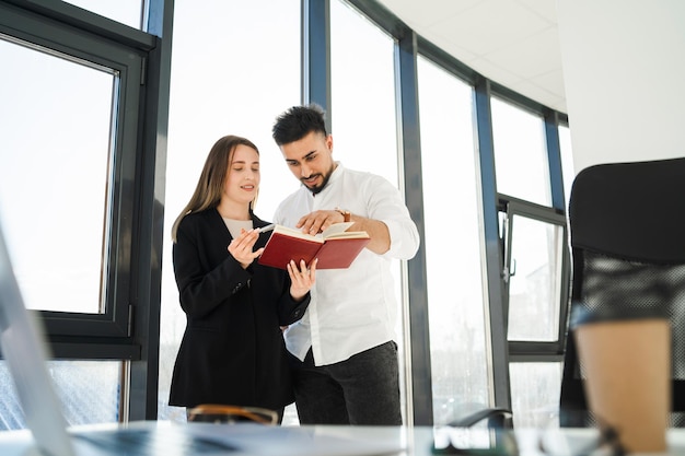 Secretary showing her boss a notepad xAMan and woman in the office