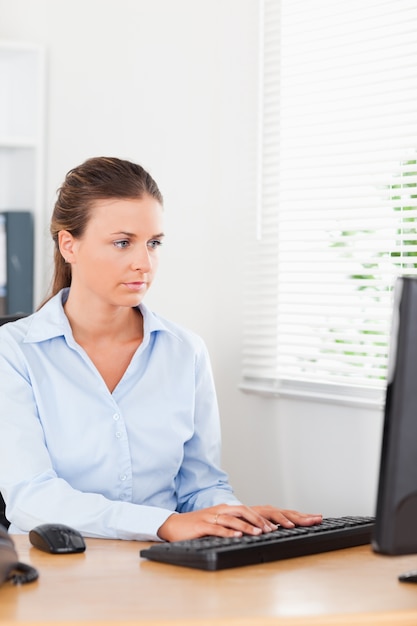 Secretary typing on keyboard in office