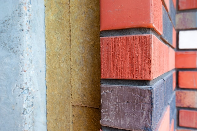 Photo section of a brick wall with insulation of a new house under construction