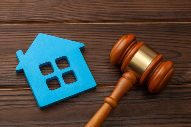 Section of property after a divorce or the purchase or sale of a home by auction. Blue house and judge gavel