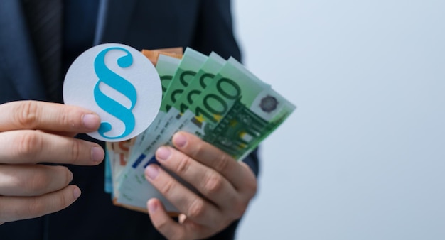 Section sign made of paper and euro bills in the hands of a man