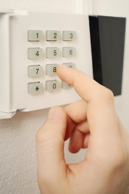 security alarm keypad with male hand closeup