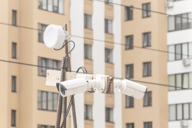 Камеры видеонаблюдения на столбе на фоне жилого дома