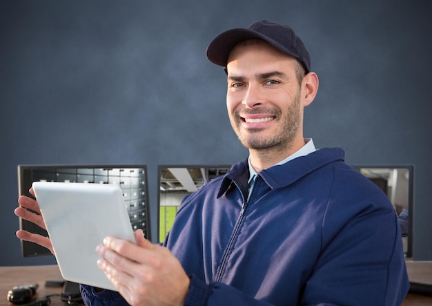 Photo security guard smiling in front of the computers with tablet