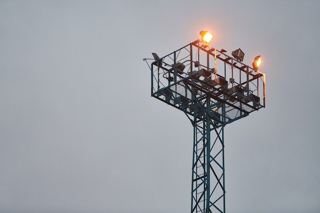 Сторожевая башня безопасности для наблюдения. Смотровая башня с прожекторами на вечернем небе
