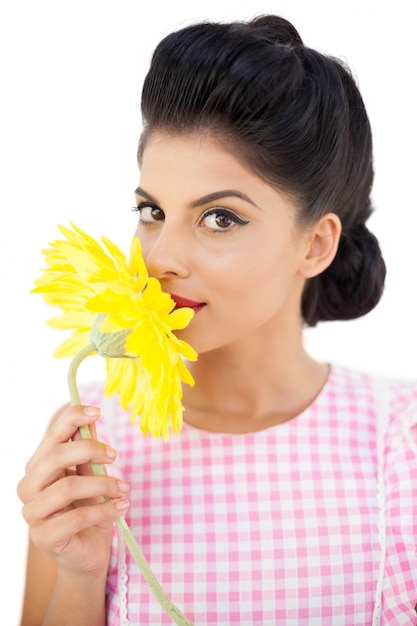 Foto modello seducente dei capelli neri che sente l'odore di un fiore