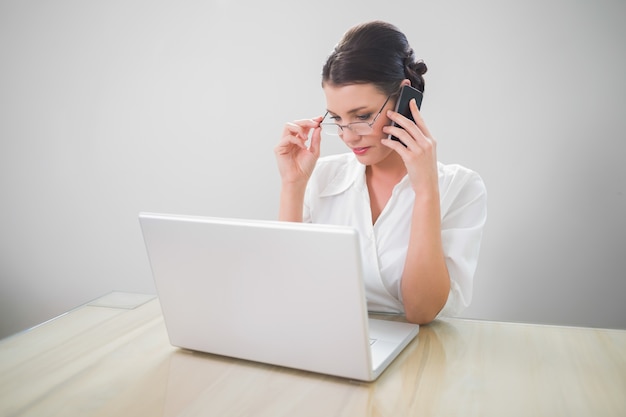 Seductive businesswoman with classy glasses phoning