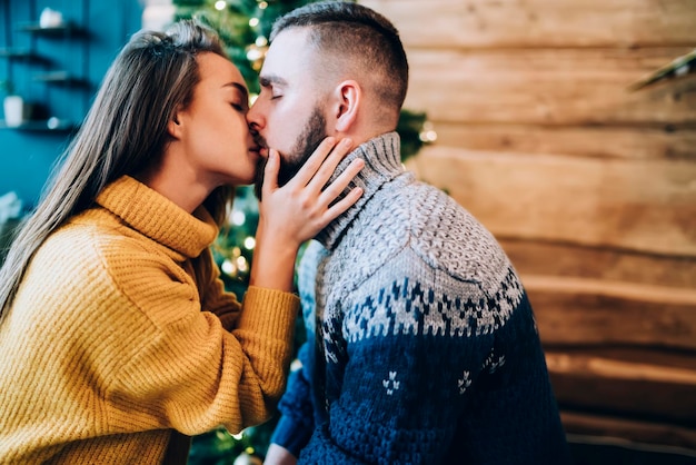 Seductive couple kissing in cozy sweaters