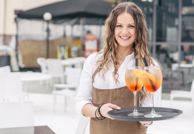 Seductive waitress bring aperitif to the customer