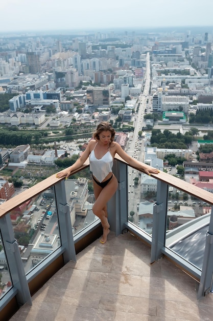 Seductive woman in underwear standing on roof of building