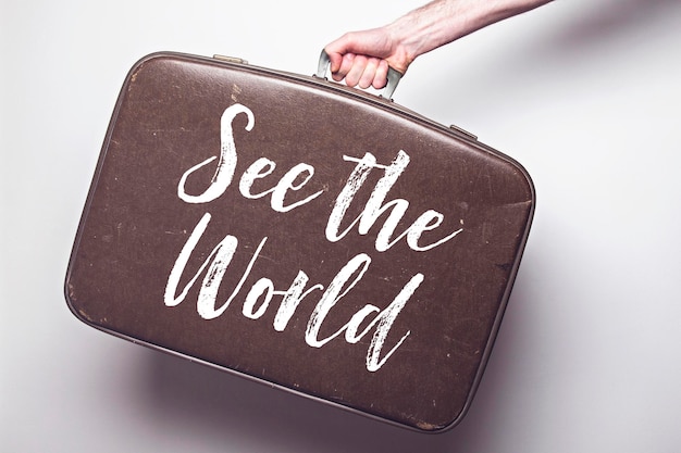 See the world message on a vintage travel suitcase