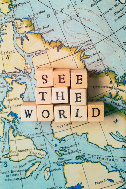 ヴィンテージの旅行地図で木製のブロックに書かれた世界を見る