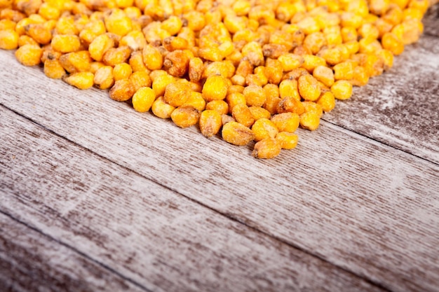 Seed of Roasted corn on wooden background in studio photo. Close up photo. Delicious salty roasted corn