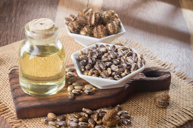 Seeds and castor oil on the wooden table Ricinus communis