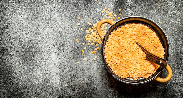 Seeds of lentils in a bowl . On rustic background.