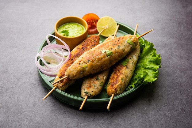 Seekh kabab gemaakt met gehakt kip of schapenvlees keema, geserveerd met groene chutney en salade