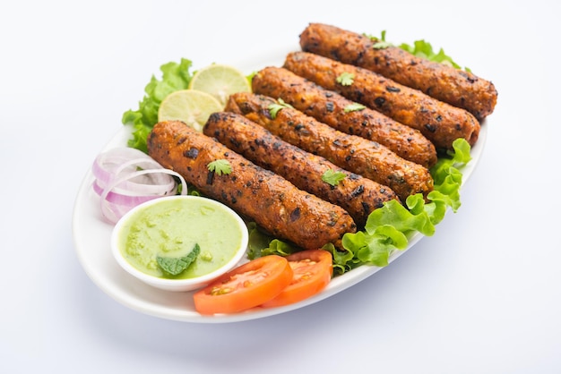 Seekh kabab gemaakt met gehakt kip of schapenvlees keema, geserveerd met groene chutney en salade