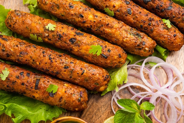 Seekh Kabab из куриного фарша или кима из баранины, подается с зеленым чатни и салатом