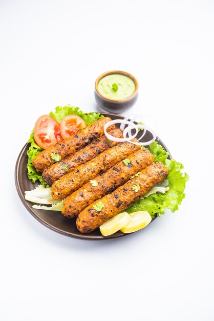 Seekh kabab fatto con pollo tritato o keema di montone, servito con chutney verde e insalata