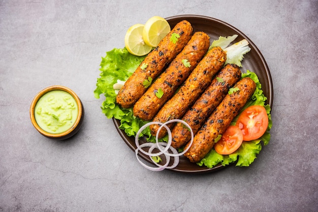 Seekh Kabab из куриного фарша или кима из баранины, подается с зеленым чатни и салатом