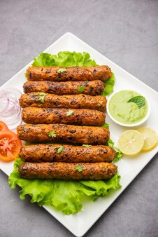 Seekh kabab fatto con pollo tritato o keema di montone, servito con chutney verde e insalata