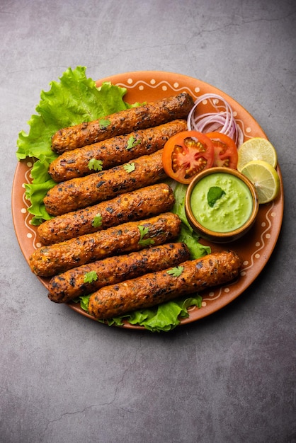 Seekh kabab fatto con pollo tritato o keema di montone, servito con chutney verde e insalata