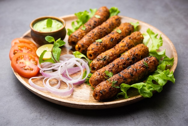 Seekh kabab из куриного фарша или кима из баранины, подается с зеленым чатни и салатом