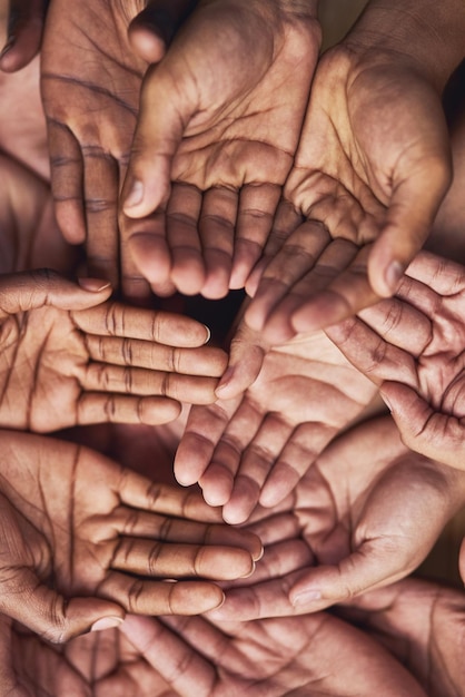 Seeking your help Shot of a group of hands held cupped out together