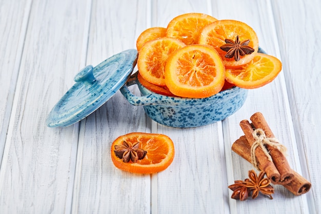 Segmenten van gedroogde sinaasappelen of mandarijnen met anijs en kaneel in een blauwe kom Vegetarisme en gezond eten